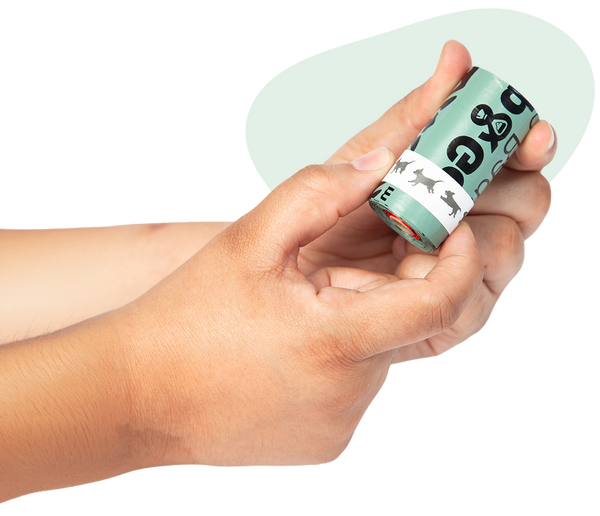 A hand holding a roll of Stop & Go bags