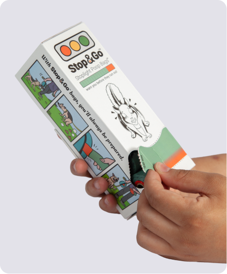 A hand opening the Stop & Go dispenser box and pulling the roll out